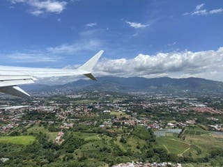 Airplane wing over the red roofs of San Jose, Costa Rica